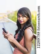 Young professional businesswoman texting on her smart phone; Edmonton, Alberta, Canada