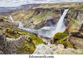 A high viewpoint of one of the waterfalls and rivers in the Haifoss valley with stunning cliffs, natural colors and rock formations; Iceland