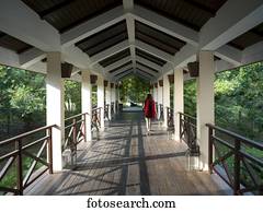 A woman walks down an open-air corridor, Ananda Hotel and Spa; Uttarakhand, India
