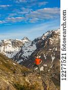 Hiker on rock outcrop overlooks Powerline Pass valley and trail, Chugach State Park, Southcentral Alaska