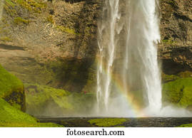 Seljalandsfoss waterfall and a rainbow in the mist; Iceland