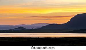 um, colorido, vista, em, pôr do sol, sobre, a, água, como, anoitecer, cria, um, silueta, de, a, colinas, de, Selfoss, em, ocidental, islândia, perto, meia-noite, onde, a, sol, não, completamente, jogo, ao redor, verão, solstice;, Selfoss, islândia