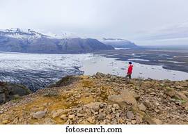 um, femininas, hiker, em, roupa morna, para, a, elementos, plataformas, borda, de, moutain, penhasco, negligenciar, a, geleira, lago, e, vale, vistas, de, Vatnajokull, nacional, Park;, islândia