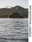 Frosty Volcano Peaking Out From Behind A Ridgeline With Aagat Island In The Foreground Near Cold Bay On The Alaska Peninsula; Southwest Alaska, United States Of America