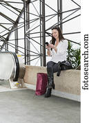 Business woman texting on her smart phone after taking a shopping break during her work day; Edmonton, Alberta, Canada Business woman texting on her smart phone after taking a shopping break during her work day; Edmonton, Alberta, Canada