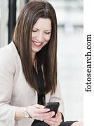 Mature business woman texting during a break from her work day; Edmonton, Alberta, Canada