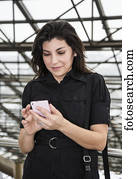 Mature business woman texting while taking a break during a business day; Edmonton, Alberta, Canada