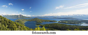 Panoramic view of a large lake in Patagonia, with snow-capped mountains and blue sky; Argentina