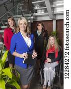 Portrait of a professional business woman with her team in the lobby of an office, one of which is a paraplegic in a wheelchair; St. Albert, Alberta, Canada
