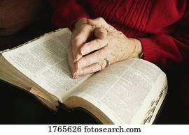 Senior praying with Bible