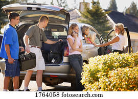 Family packs the car for a trip