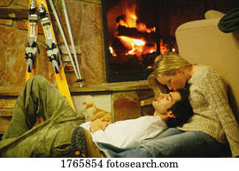 Couple relax by fireplace
