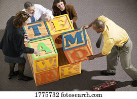 Businesspeople putting together blocks Businesspeople putting together blocks
