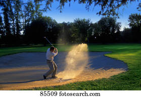 Golfer chipping out of sand trap