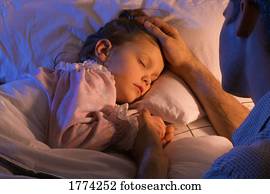 Father beside sleeping daughter bed
