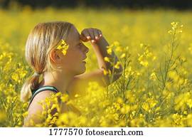 Young girl in a field of yellow flowers