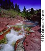 Small waterfall over red rocks in mountain Red Rock Canyon Waterton National Park