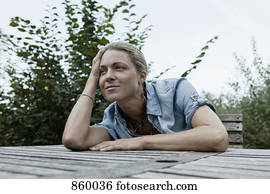 A woman sitting at an outdoor table, non-urban scene
