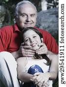 Portrait of a senior man and his granddaughter smiling