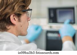 Male worker in thread factory, using touch screen