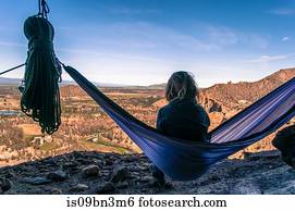 Rock climber on hammock on summit, Smith Rock State Park, Oregon, USA