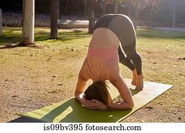 Woman practising yoga in city park
