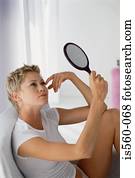 Woman using a hand mirror