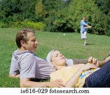 Couple relax as child plays.