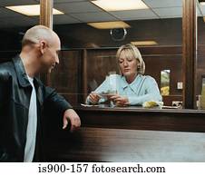 Betting shop worker counting money for customer