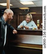 Betting shop worker counting money for customer