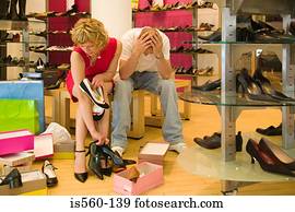 Man despairing as woman chooses shoes