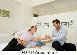 Family playing on bed
