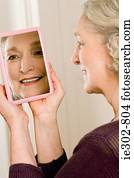 A senior woman looking in a mirror