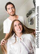 Hairdresser and girl with long hair