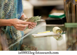 Shop keeper counting money in shop