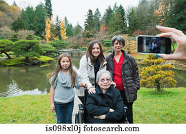 Woman photographing multi generation family