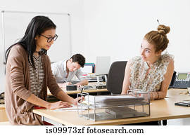Young women in office, man working in background