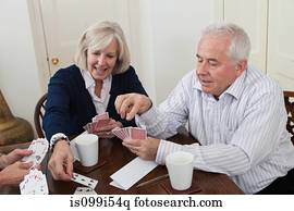 Mature woman and senior man playing cards