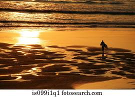 Surfer on beach in Cornwall, UK