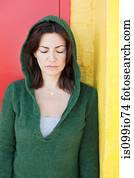 Woman in green hooded top with eyes closed