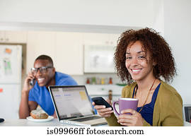 Woman texting on smartphone, man in background