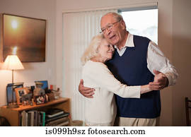 Senior couple dancing in living room