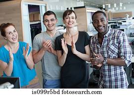 Four people clapping in office interior