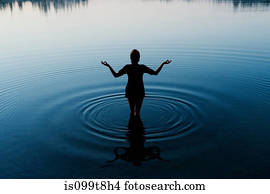 Woman meditating in peaceful lake