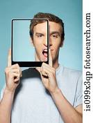 Man covering half his face with digital tablet