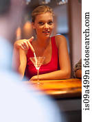 Woman ordering another drink at bar