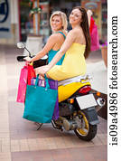 Women carrying shopping bags on scooter