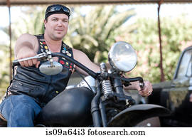 Man in leather vest on motorcycle