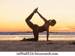 Woman practicing yoga on beach