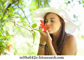 Woman smelling flower in park
